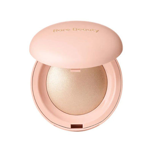 Compact powder with a pink lid on a white background, featuring the brand 'Rare Beauty'.